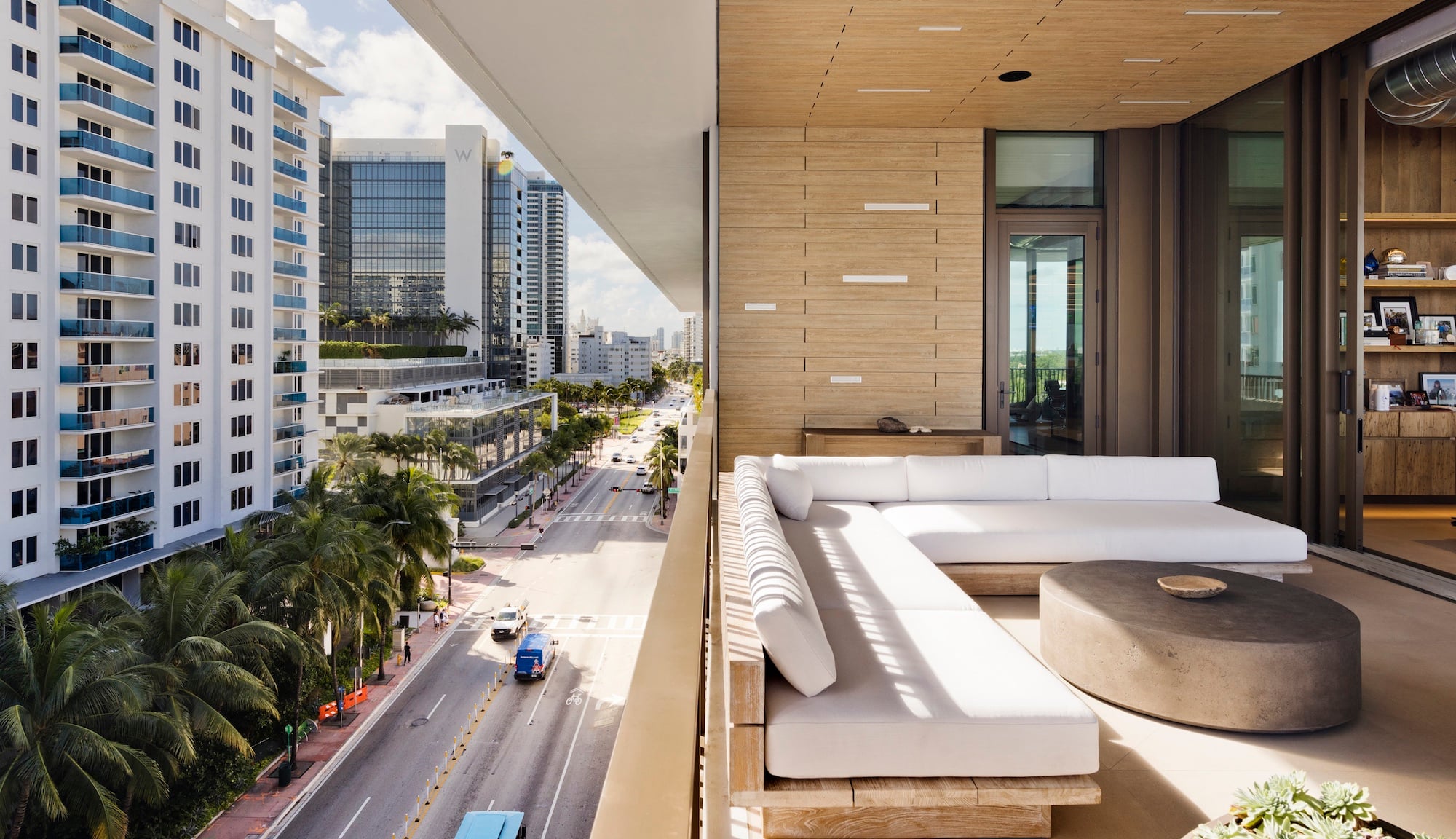 City View of buildings, palm trees, and roads from an opened window