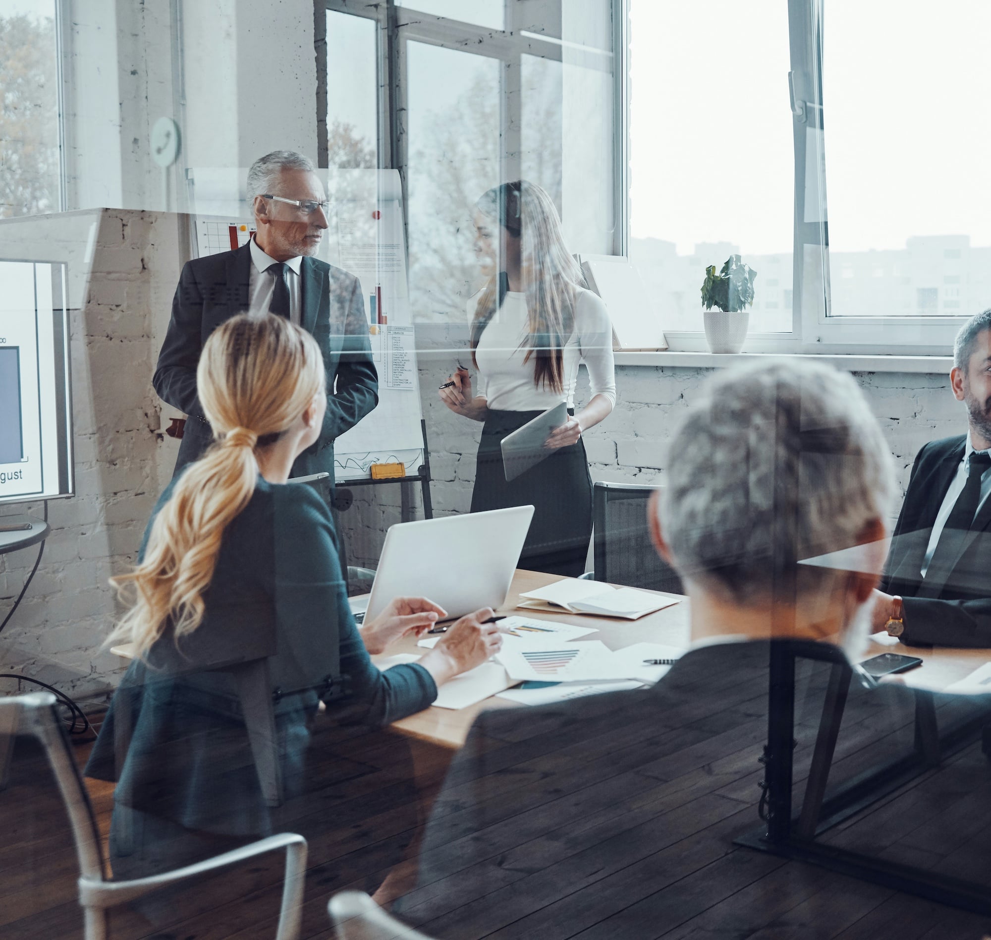 People having a presentation in a meeting through a window
